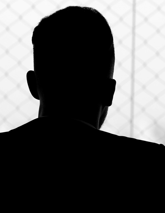 A silhouetted person seen from behind against a bright window