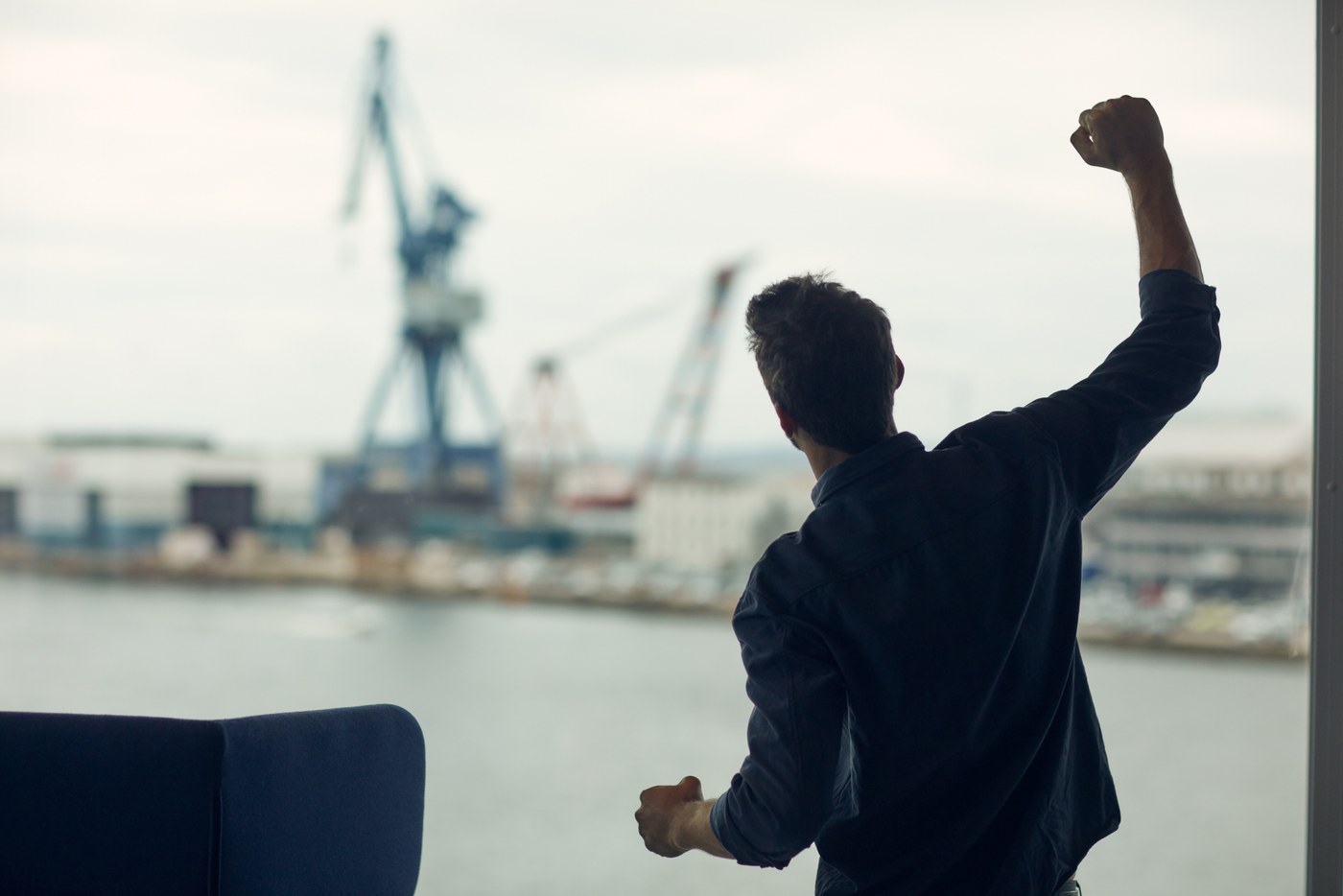 A man raising his arm beside an office window