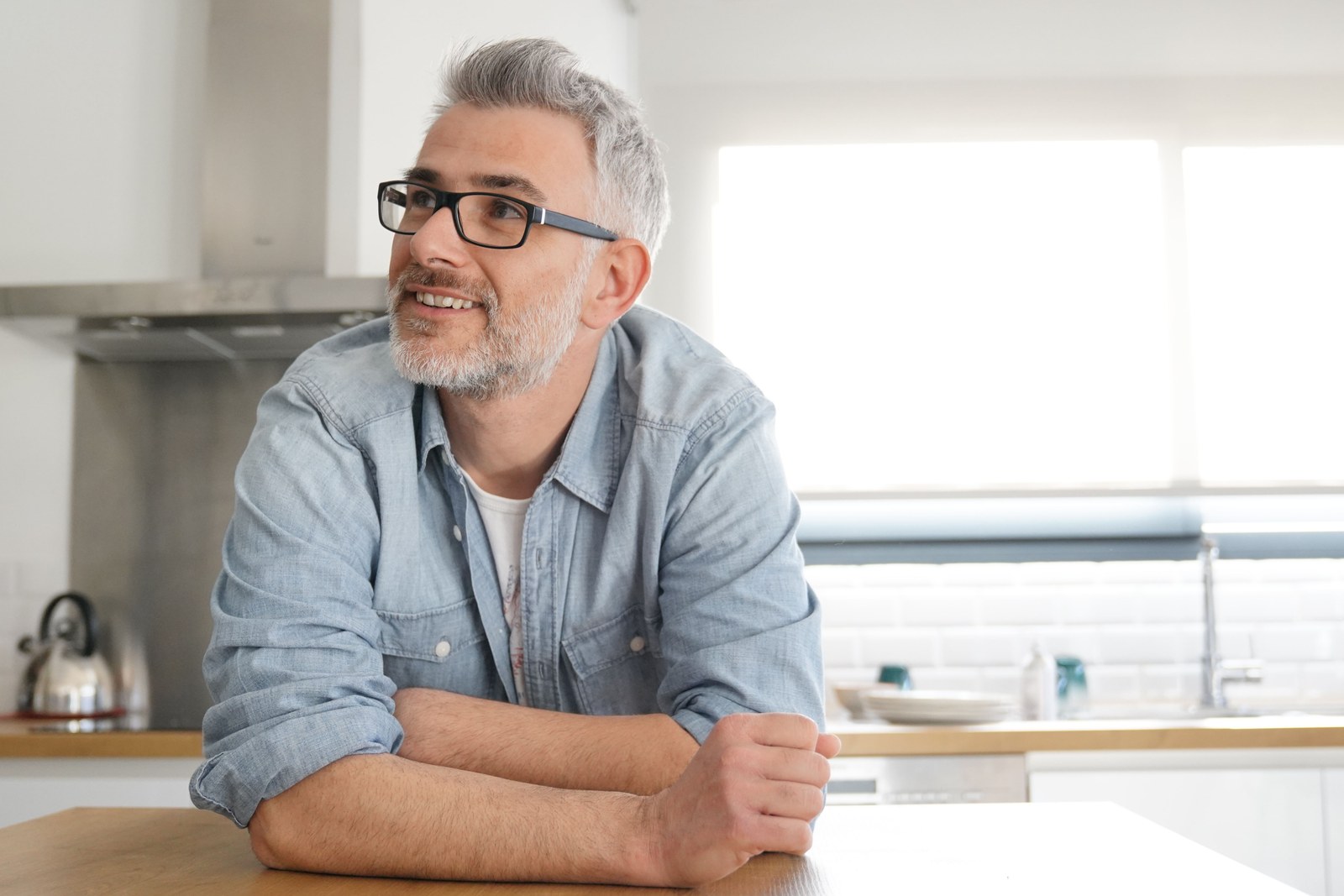 A man seated at a kitchen worktop